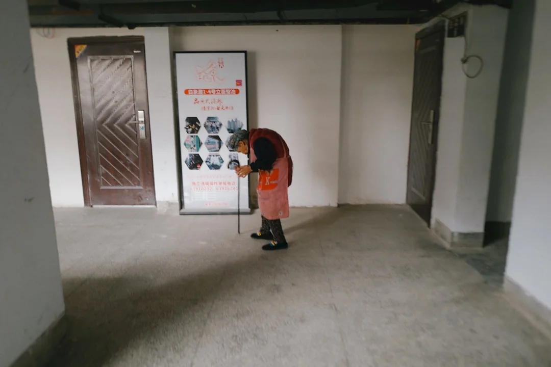 An adult male cleaning a glass window indoors, focusing on household chores and cleanliness.